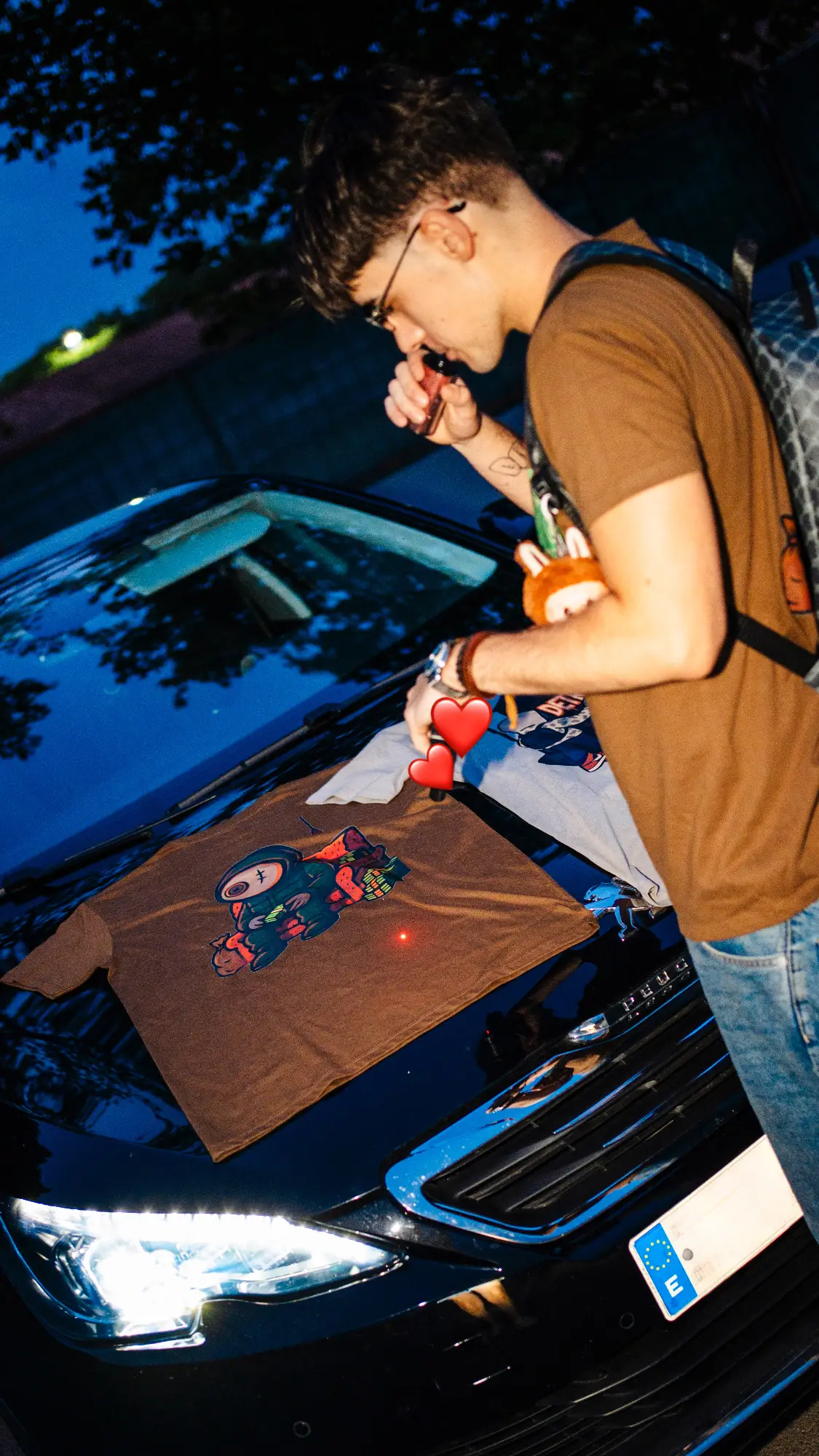 Fotografía de DETRAPO: prendas sobre el capó de un coche y modelo con camiseta marrón